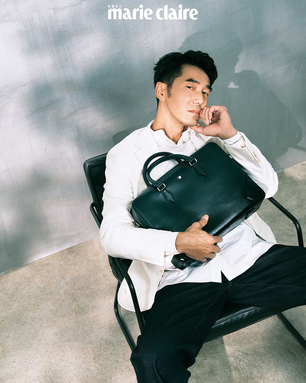 飄帶白襯衫、白色棉麻西裝外套，both by Boss；深藍牛仔寬褲，Loewe；萬寶龍大師傑作系列公文包，Montblanc。