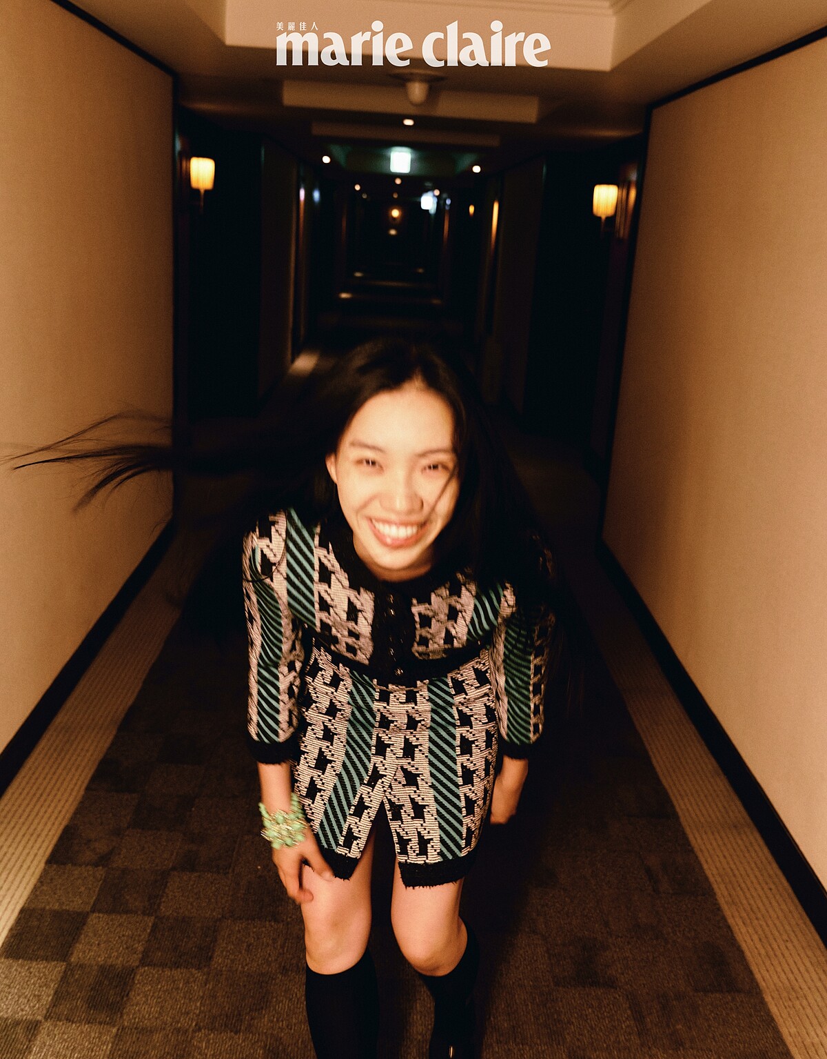 綠色千鳥格紋針織衫、綠色千鳥格紋短裙、綠色花朵手環、黑色長襪、黑色蝴蝶結瑪莉珍鞋，all by CHANEL。