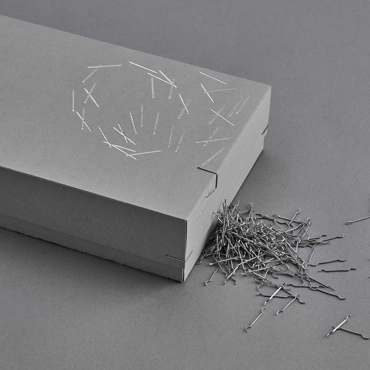 塵封的收納盒，灰卡紙及直角釘暗示瑪德蓮貝殼紋路。