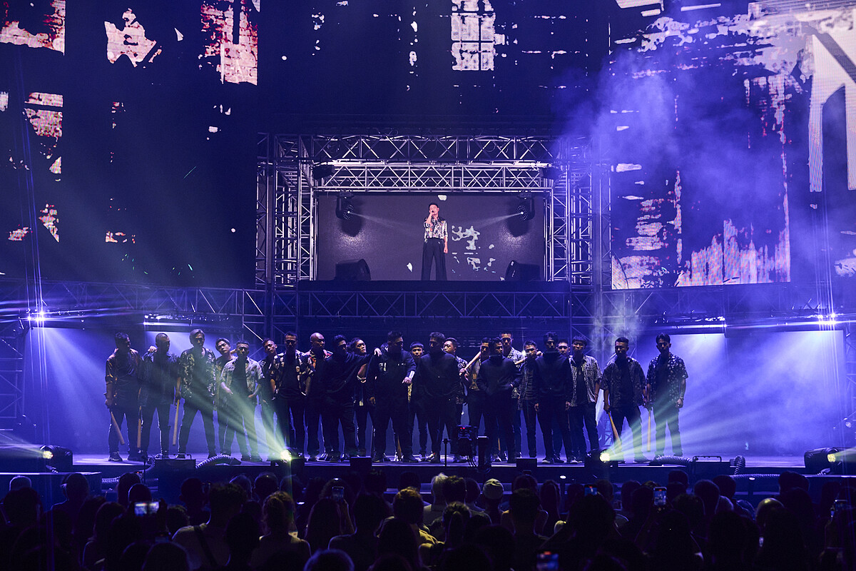 《角頭》中飾演「仁哥」的王識賢，站在二樓舞台獨唱，俯瞰電影中人氣組合「五虎將」成員鄭人碩、張再興、黃尚禾、吳震亞與唐振剛，以及大批黑衣人在現場飆戲爭鬥