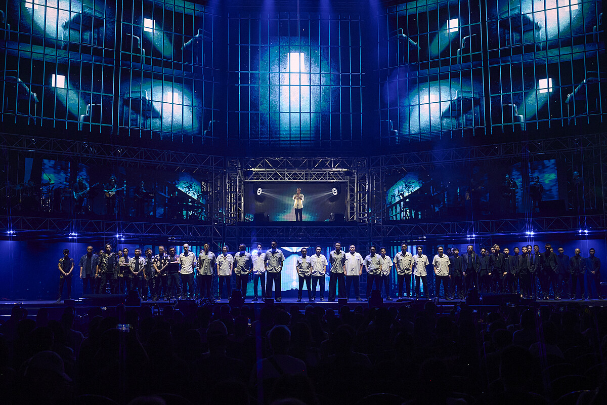 荒山亮身著囚服站在舞台中央高台，領軍全體 70 位演員登台唱〈悲歌〉謝幕