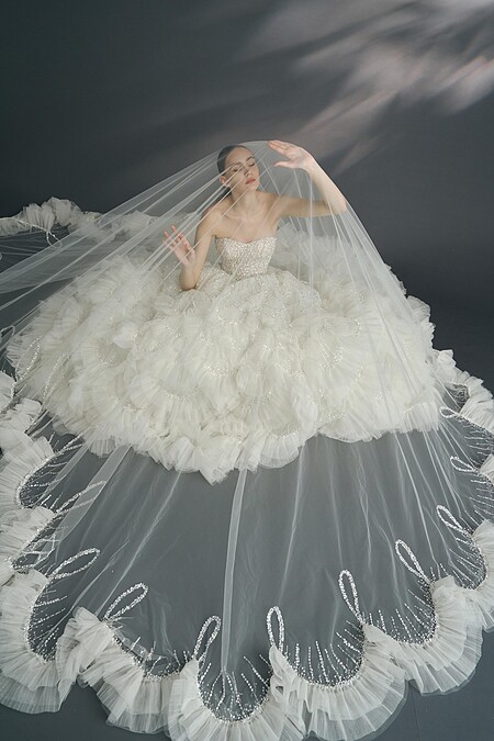 壓褶荷葉白紗《Narcissus 水仙花》，以菱格設計延伸至裙擺的圓弧交錯圖騰。（LinLi Boutique 提供）