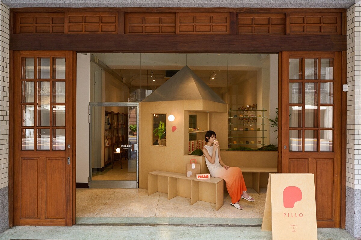 門口有著醒目的造型木作，靈感取自吐司模具簡潔的線條，巧妙融合了老建築的古典氛圍與現代設計。