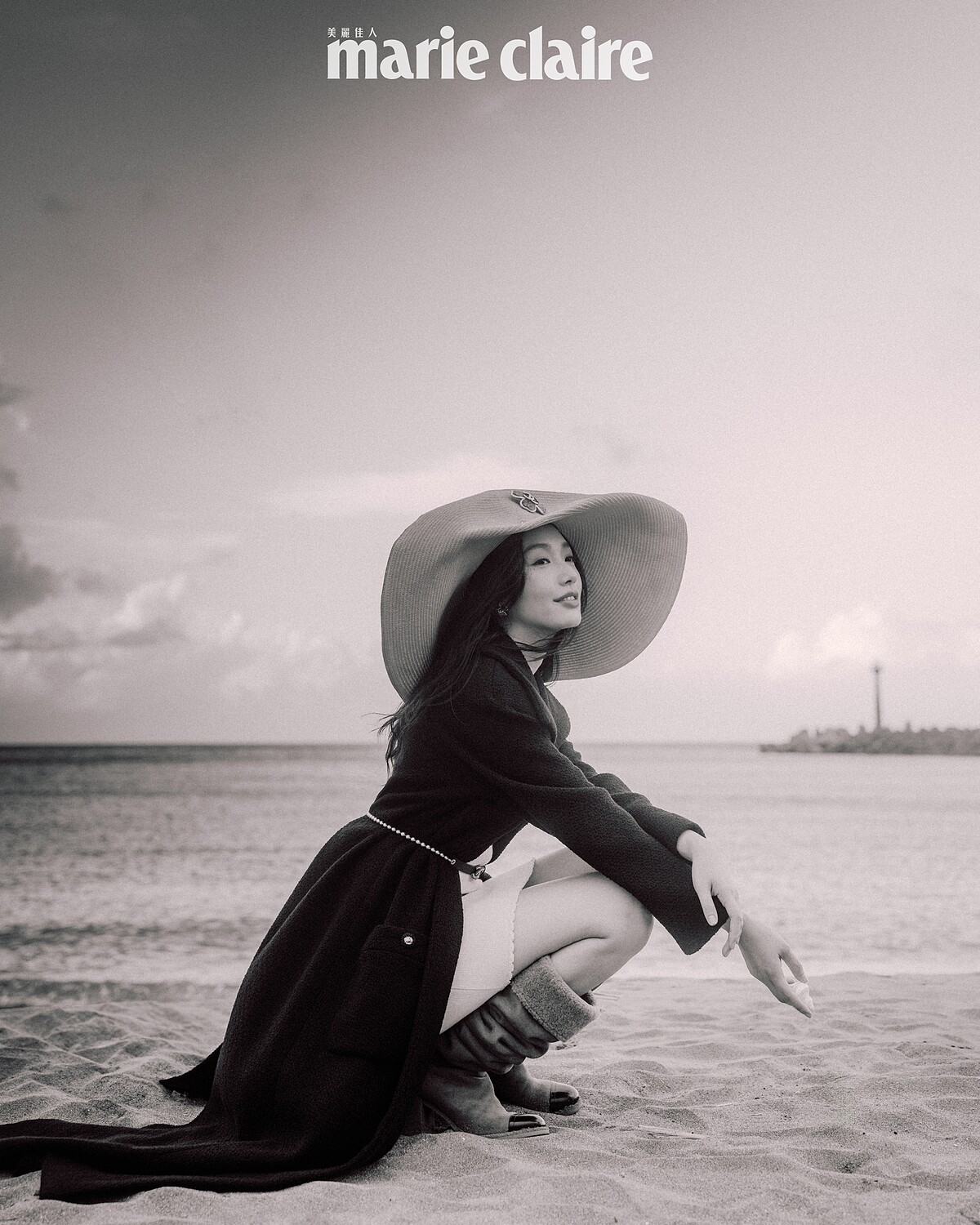 （Cecilia Choi）黑色斜紋軟呢長版綁帶大衣、白色針織洋裝、粉色寬沿草帽、皮穿鍊腰鍊，all by Chanel。