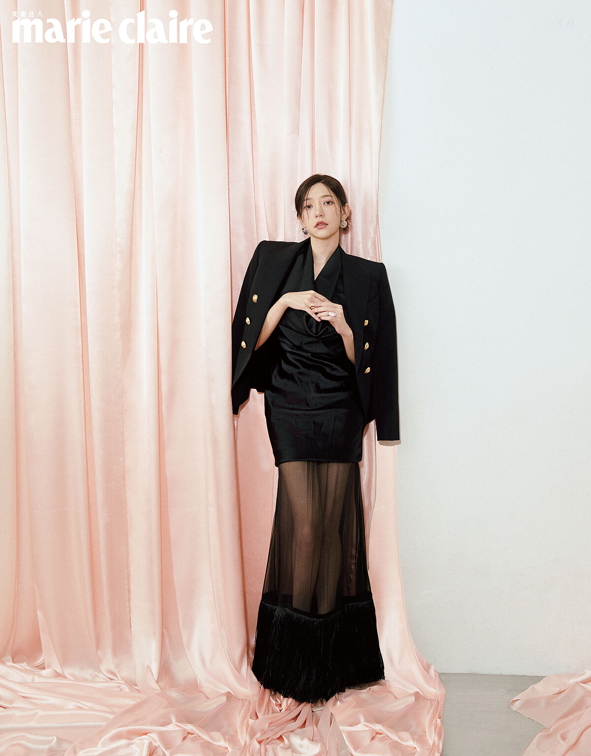 服裝配飾／黑色掛脖網紗流蘇套裝，Ferragamo；黑色金釦墊肩西裝，Balmain；銀色logo耳環，Versace；金色碎鑽戒指、金色素面戒指，both by APM Monaco。彩妝／24K純金奢緞光妝前乳、24K純金光透精華粉底、OMBRES G高訂深邃四色眼影盤、ROUGE G紅寶之吻高訂唇膏，all by Guerlain