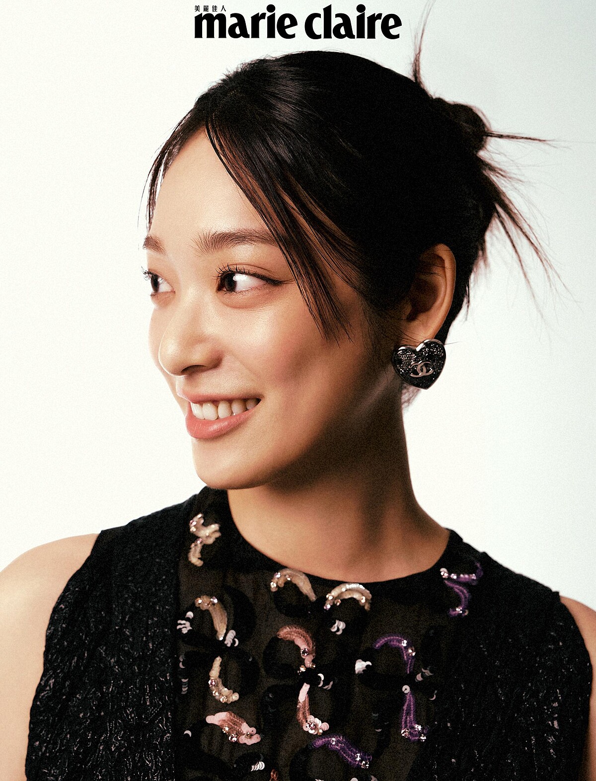 黑色刺繡背心、黑色連身褲、珍珠腰帶、心型耳環，all by CHANEL。