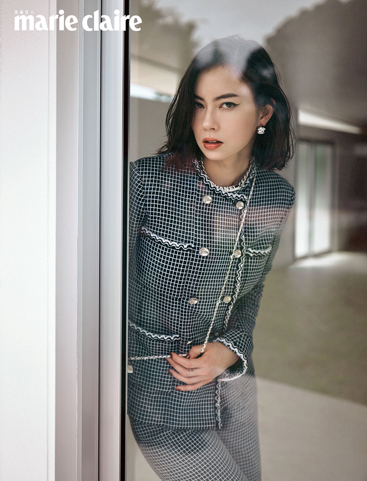 黑白斜紋軟呢外套、黑色斜紋軟呢長褲、銀色金屬耳環、銀色雙C logo掛飾，all by Chanel。