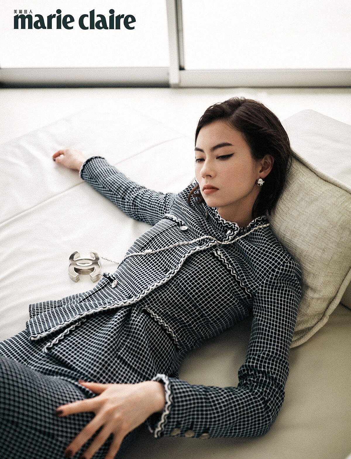 黑白斜紋軟呢外套、黑色斜紋軟呢長褲、銀色金屬耳環、銀色雙C logo掛飾，all by Chanel。