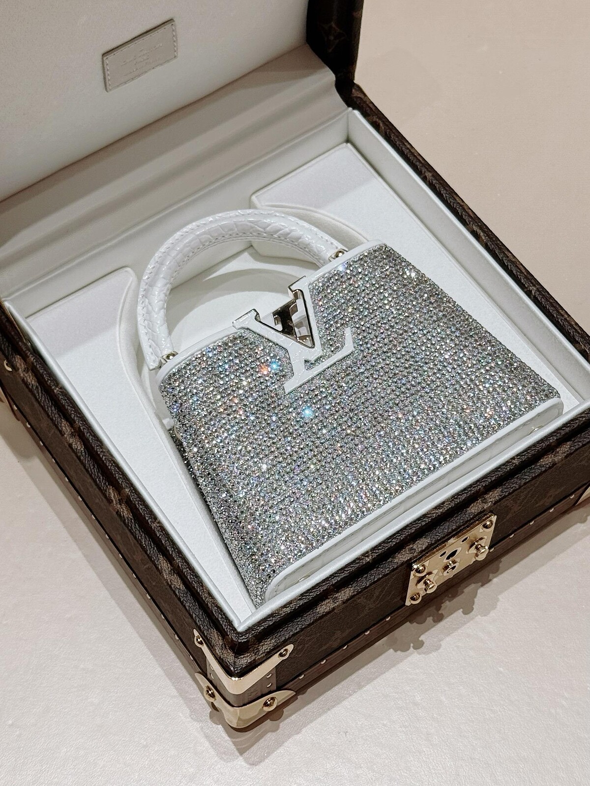 【SOGO獨家商品】Capucines Nano 水晶鑲綴與白色鱷魚皮提把翻蓋,NT$745,000。