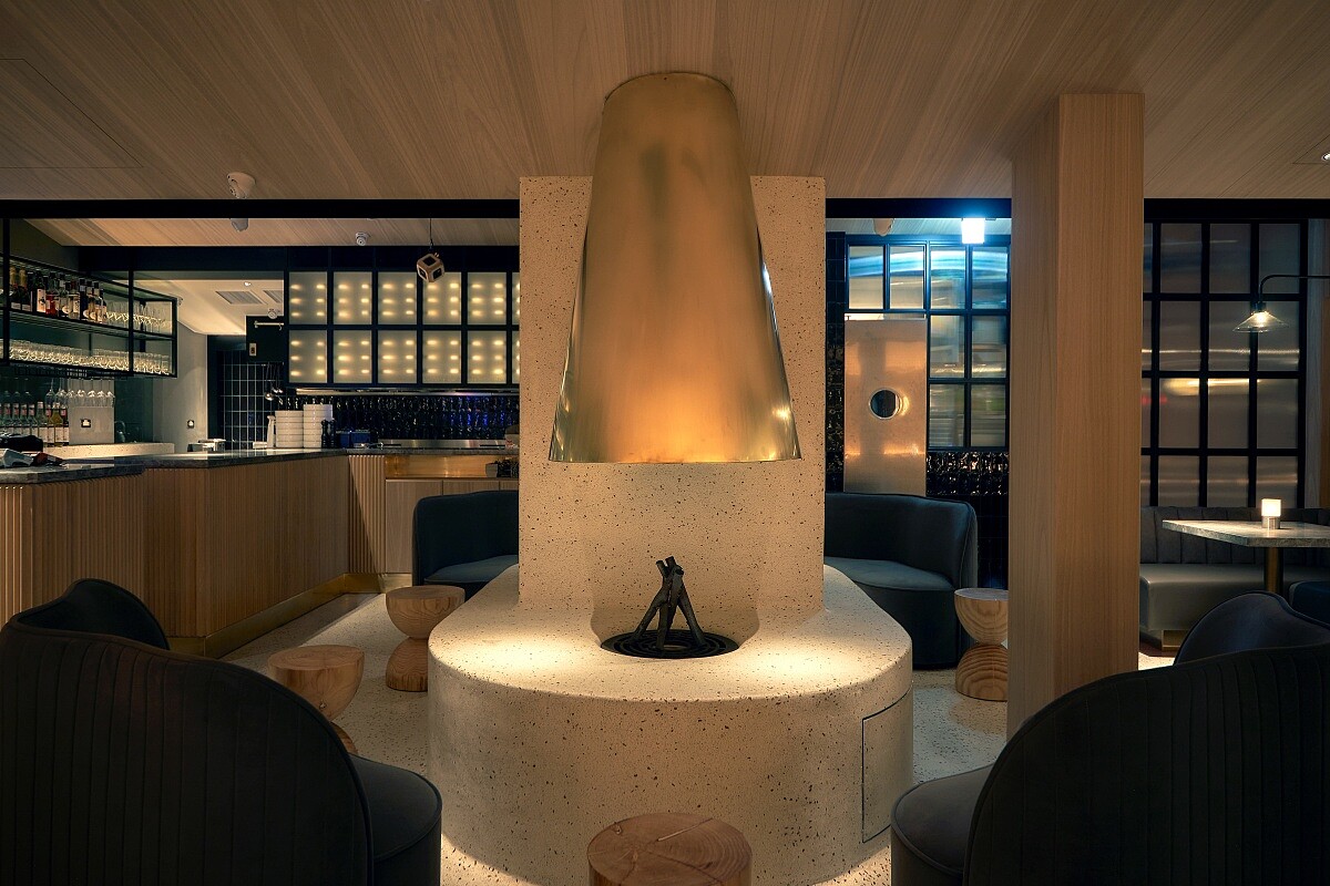 台北店空間以奶油色磨石子材質打造的無接縫地板，並延伸至火爐。