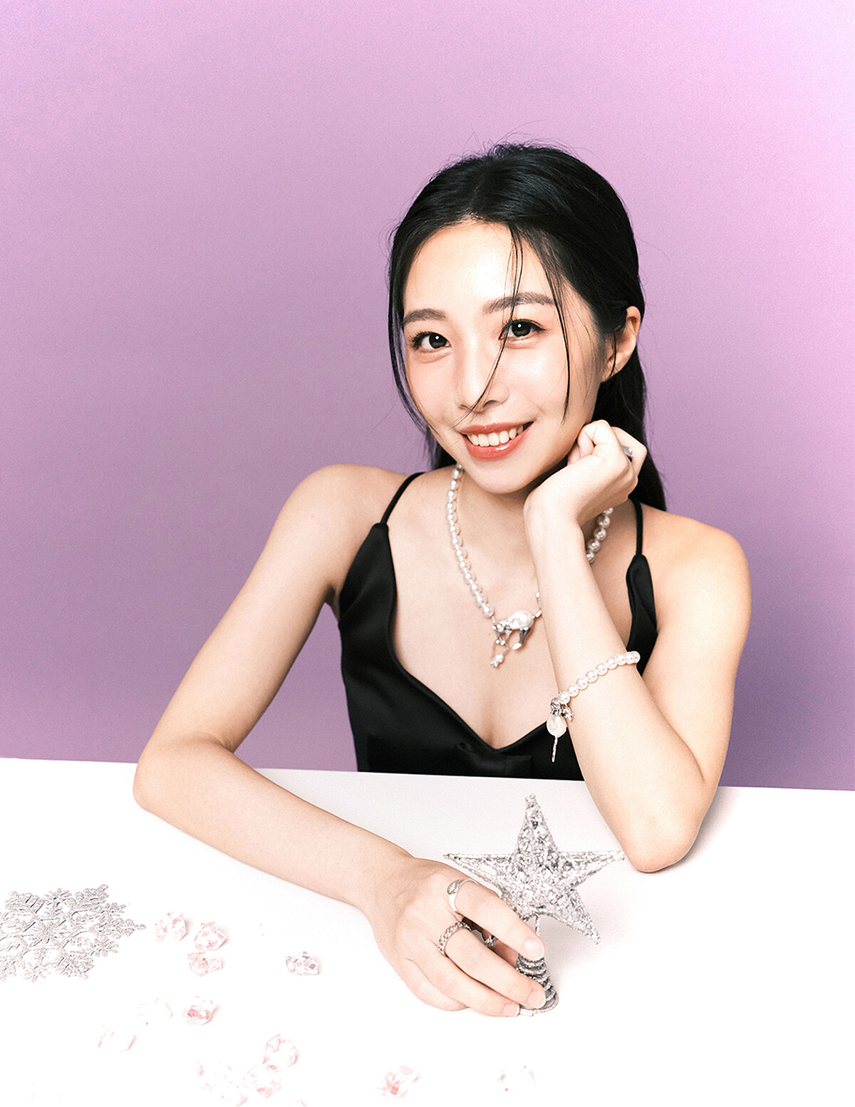 黑色蝴蝶結短洋裝、珍珠項鍊、珍珠手鍊，all by Marc Jacobs。