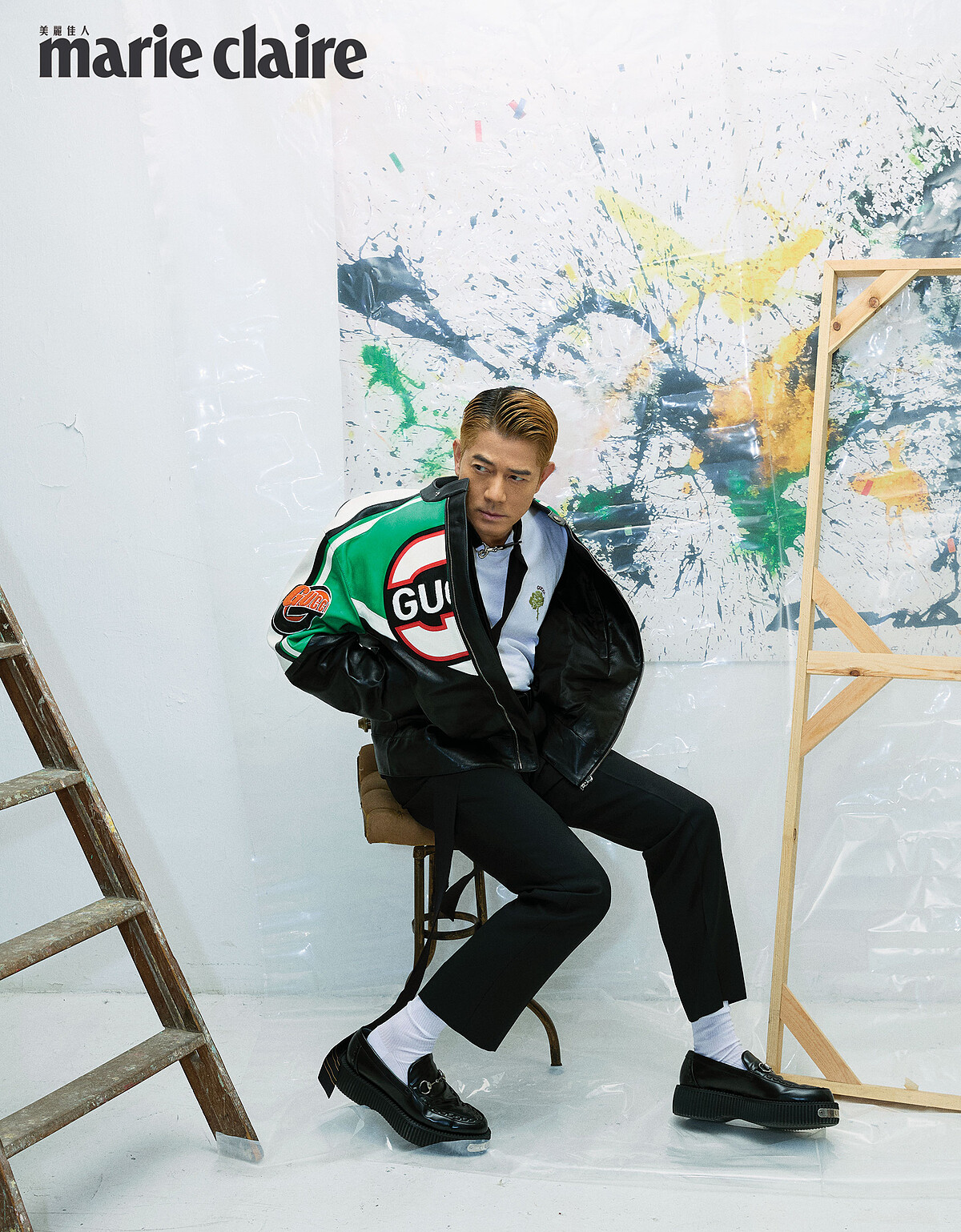 綠黑撞色夾克、白色棉質 T-Shirt、黑色窄版正裝褲、黑色領巾，all by Gucci。