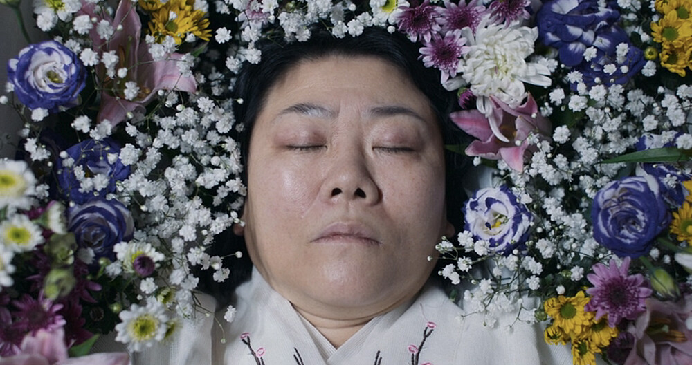 賢珠的媽媽惟熙無法講話且帶著花香是因為已經被安置於棺木中了。