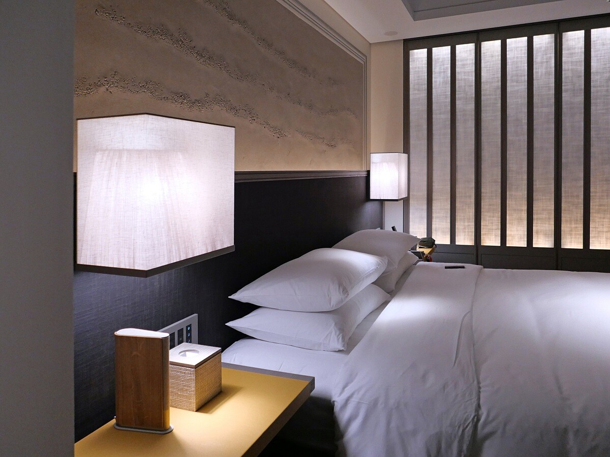 夜晚床邊繃布燈具散發出柔和的光線。