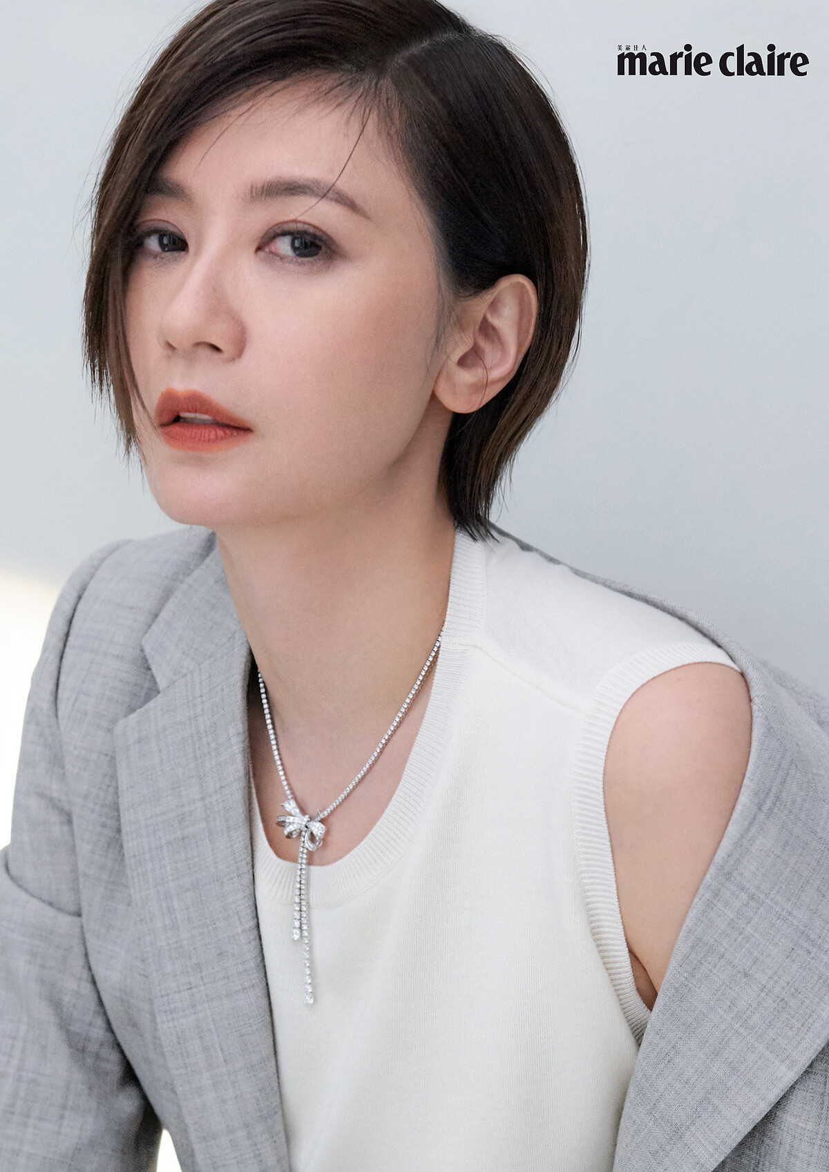 灰色西裝外套、米白針織背心、灰色寬褲,All by Loewe; Tilda's Bow系列多形切割鑽石項鏈,Graff。