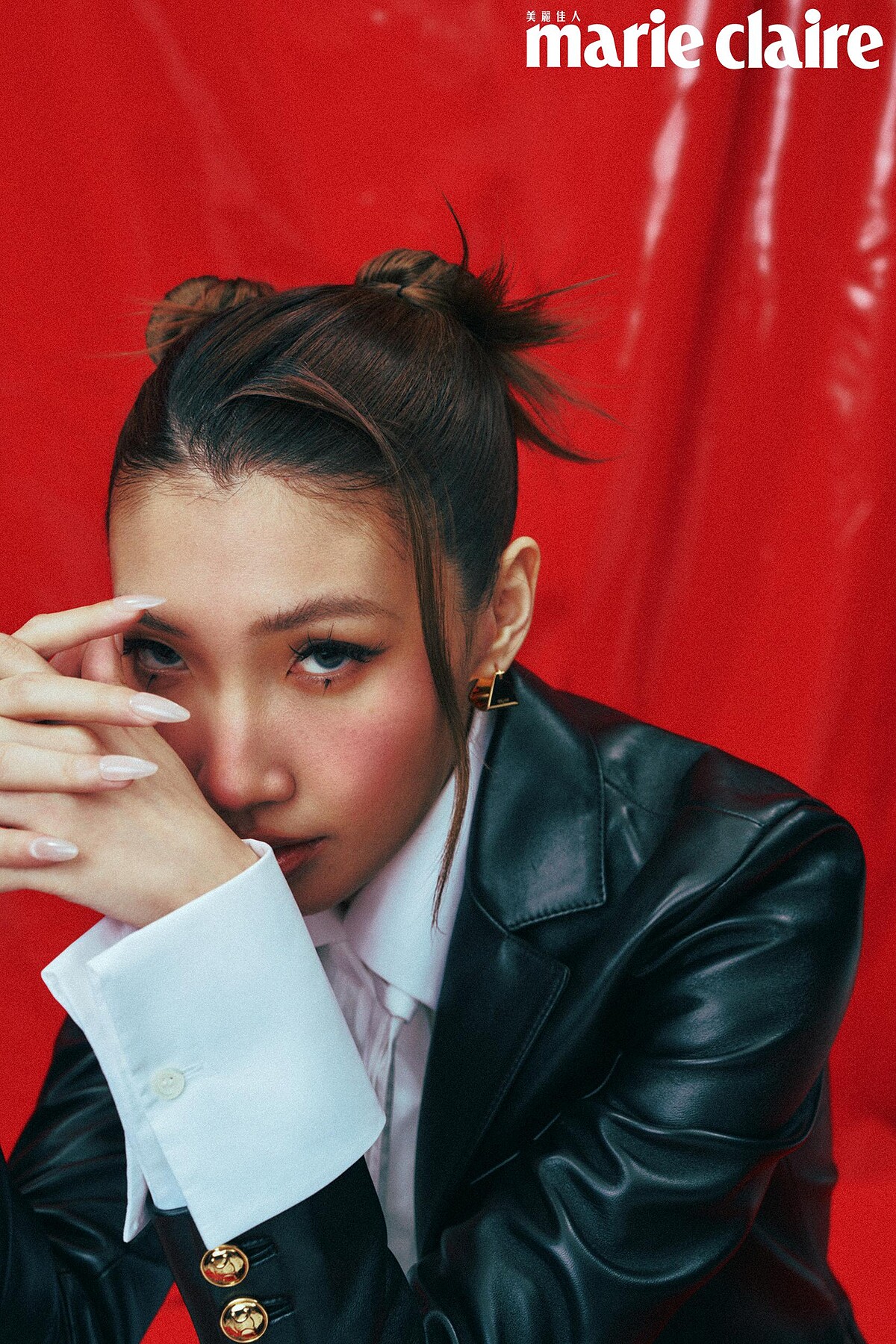  白色棉質垂墜襯衫，Loewe；黑色柔軟羊皮革西裝外套、金色飾面金字塔形圈式耳環，both by Celine by Hedi Slimane。