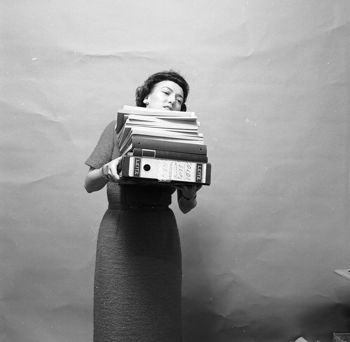 circa 1955: A secretary struggling to see over her load of files. (Photo by Carsten/Three Lions/Getty Images)｜&copy; Getty Images
