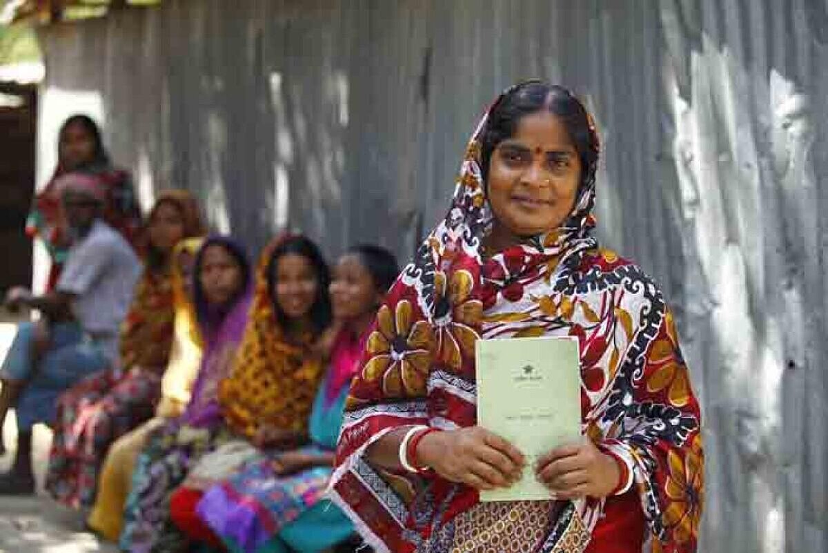 婦女的手裡拿著鄉村銀行的流程手冊。她們為了要能貸款,必須要一步一步遵守所有銀行所開出以婦女為考量的約定。