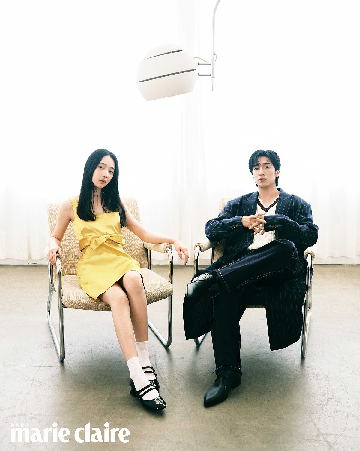 婁：深藍條紋大衣、麻花針織背心、深藍工裝褲、黑色尖頭皮鞋，all by Coach。 沐：黃色緞面洋裝，黑色瑪莉珍平底鞋，both by Coach。