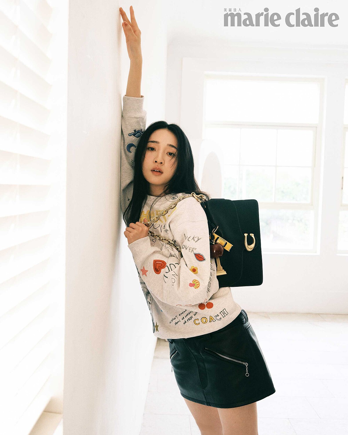 塗鴉印花衛衣、黑色皮裙、Tabby黑色肩包、黃色計程車手袋掛飾、蘋果手袋掛飾、艾菲爾鐵塔手袋掛飾，all by Coach。