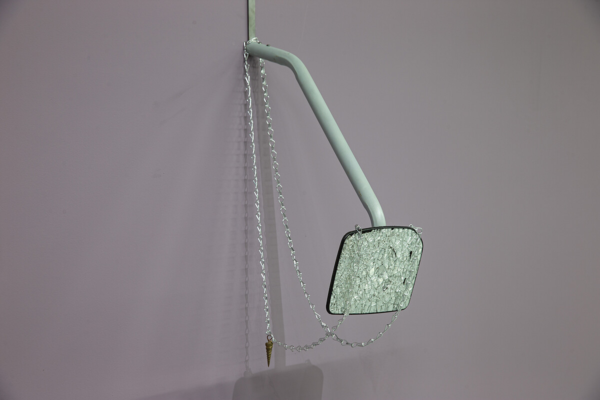 黃麗音，《注意後方來車》，2025，破碎的後視鏡、銅、鋁、鍊條，115 &times; 22 &times; 31公分。圖像由北美館提供。