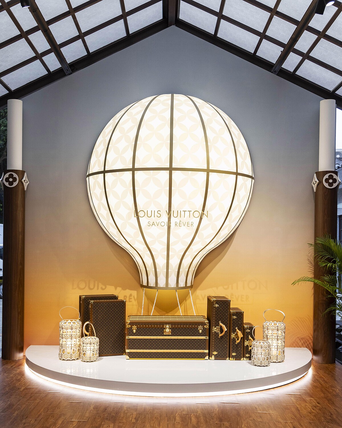 以Monogram花朵發光為設計的熱氣球設計與經典硬箱裝置展現了升空高飛的旅行概念。