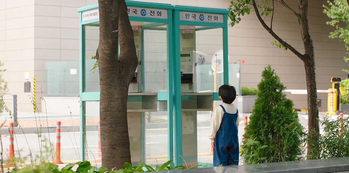 一個小男孩盯著空空的電話亭看著