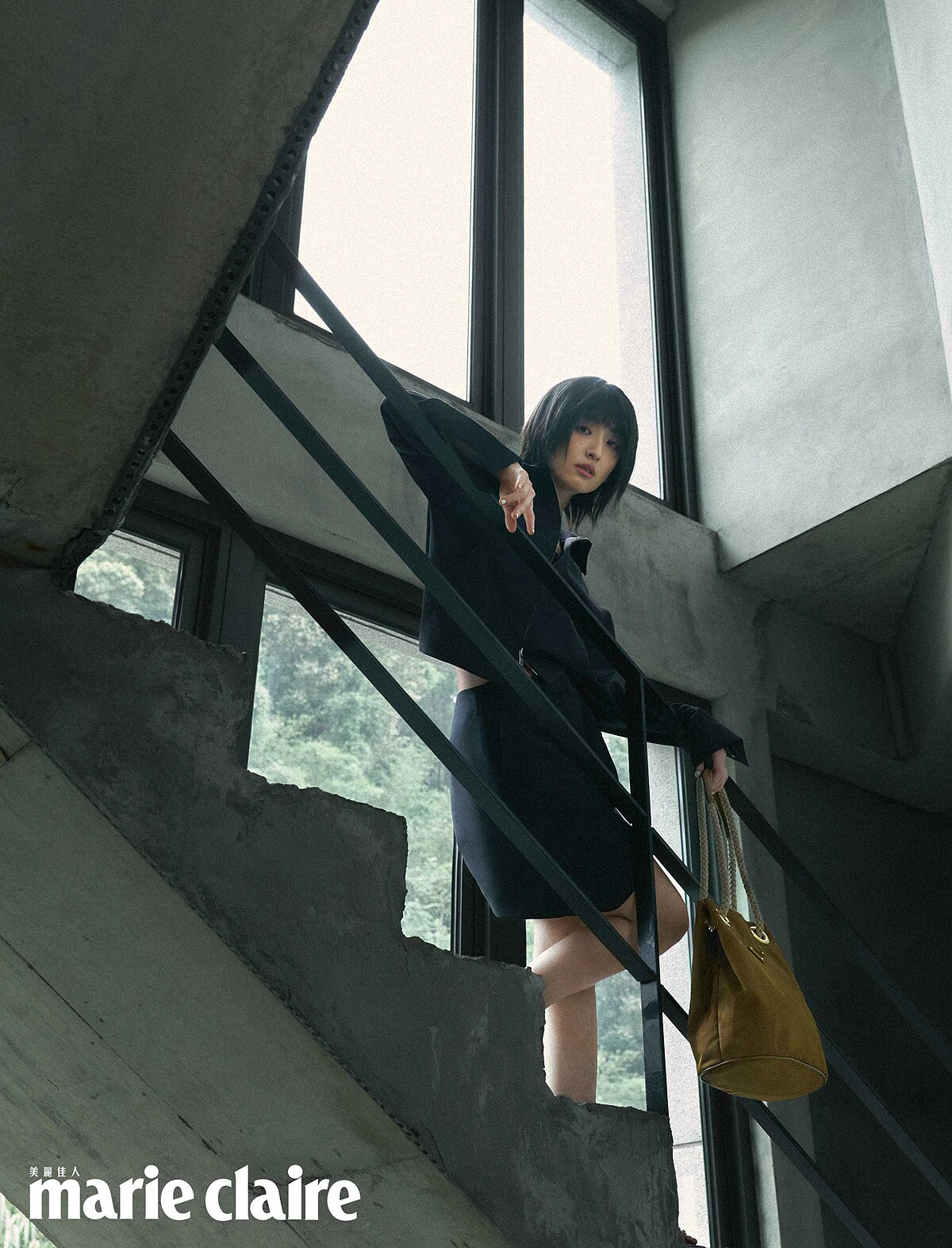 深藍色羊毛夾克、深藍色羊毛短裙，皮革流蘇便鞋、Re-Nylon 繩索水桶包，All by Prada。