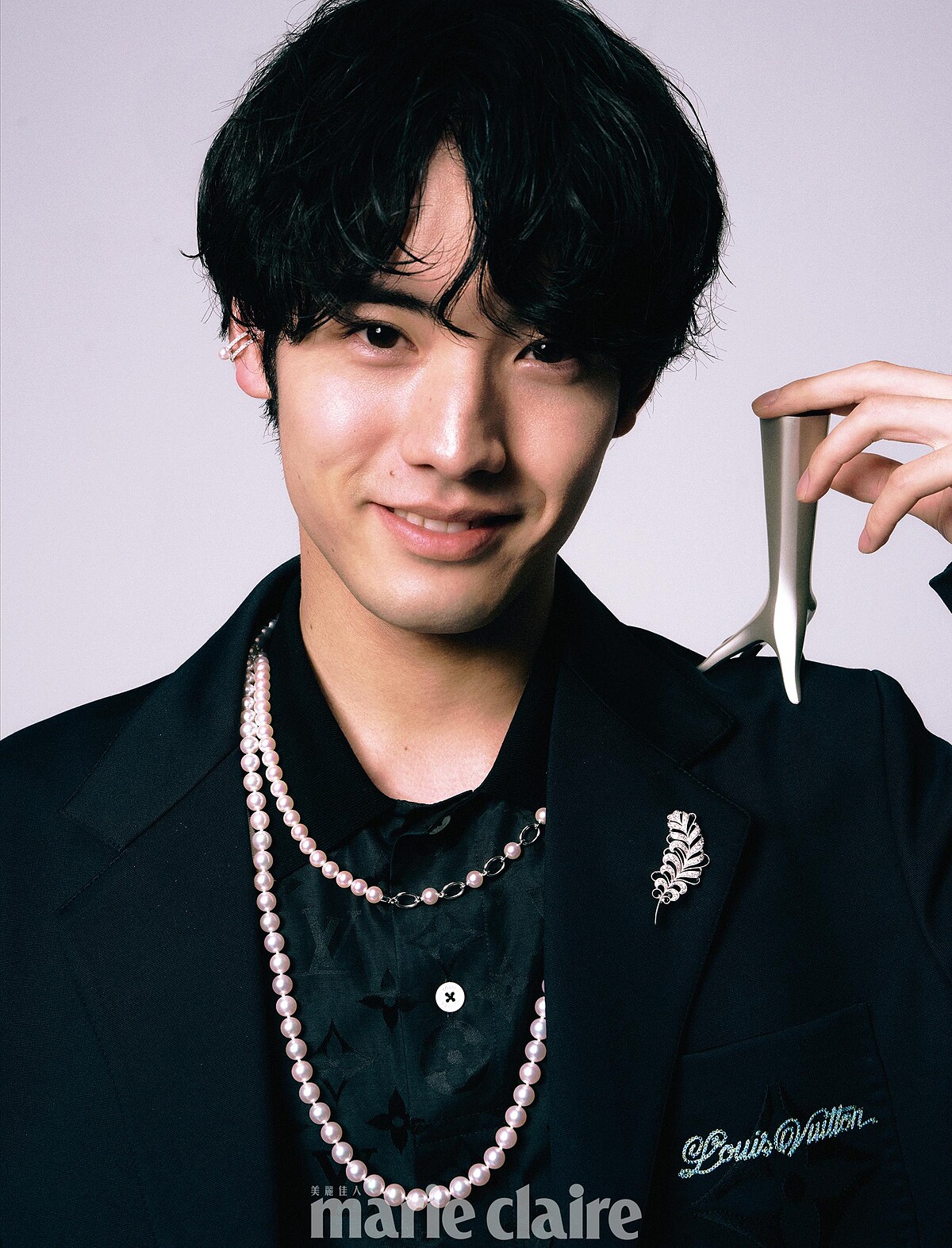 刺繡西裝外套、黑色Polo上衣，both by Louis Vuitton；M Code Liberte 珍珠項鍊、長珍珠項鍊、鑲鑽耳骨夾、羽毛造型鑽石胸針，all by Mikimoto。 