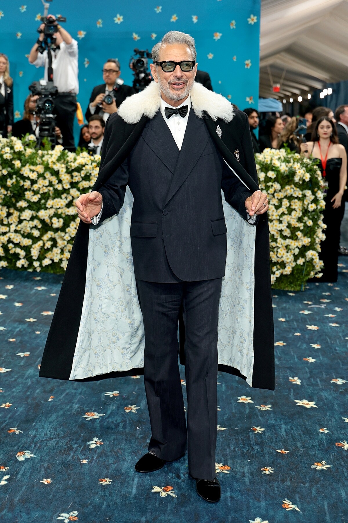 Jeff Goldblum 於 2025 Met Gala 紅毯，身穿正裝外搭白毛領黑色長披風