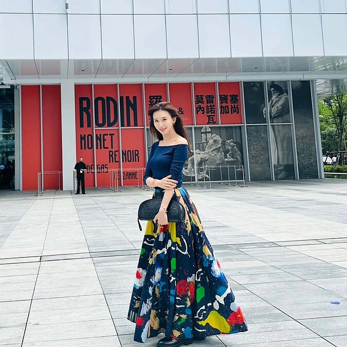 林志玲出席富邦美術館展覽，身穿不對稱斜肩藍色上衣搭配彩色印花長裙