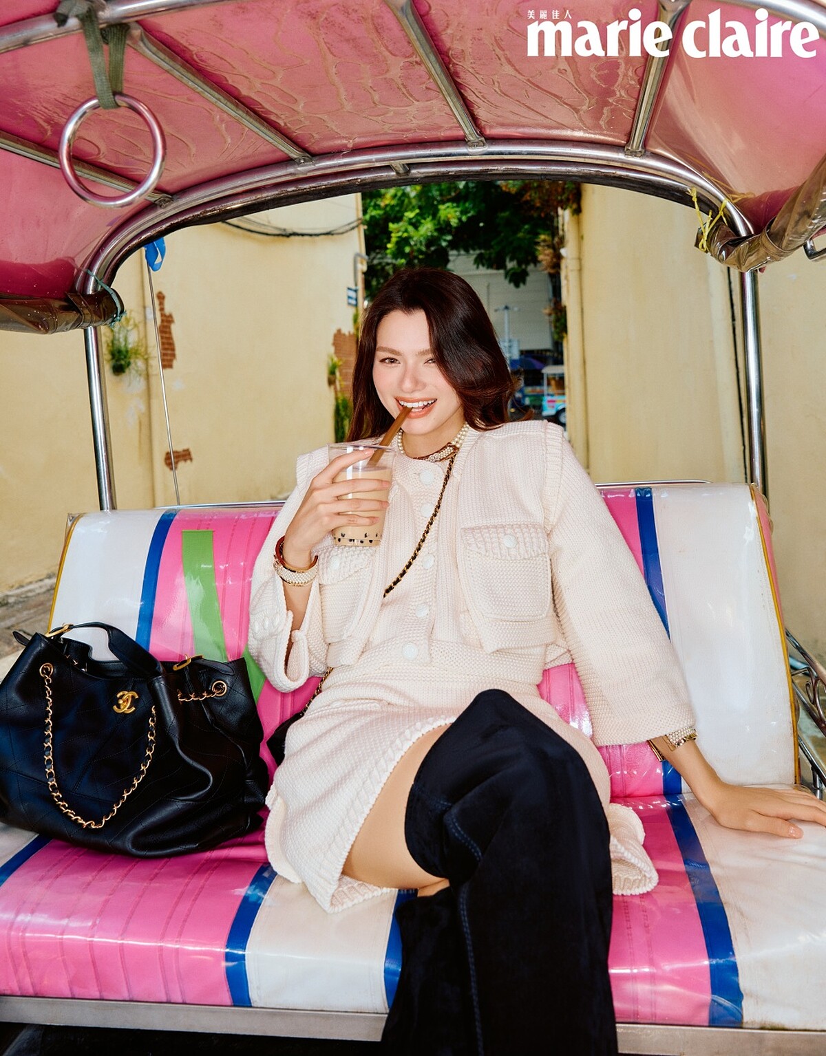 米色飾以珠寶鈕釦短版外套、米色飾以珠寶鈕釦短裙、金白色鑲以水鑽短項鍊、金白色鑲以水鑽手環、金白色飾以珠寶與水鑽腰帶、黑色麂皮與皮革過膝長靴、黑色菱格紋皮穿鍊迷你肩背包，All by CHANEL。