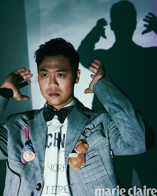 煙灰色工裝直條紋西裝外套、白色 Logo 標語襯衫、煙灰色工裝直條紋西裝褲，All by Moschino；彩色星星領結、黑色皮鞋，Both by Paul Smith。