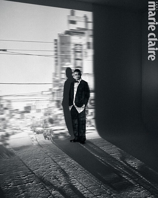 深灰色印花襯衫、深灰素面西裝褲，Both by Moschino；白色星星領結、黑色皮鞋，Both by Paul Smith。