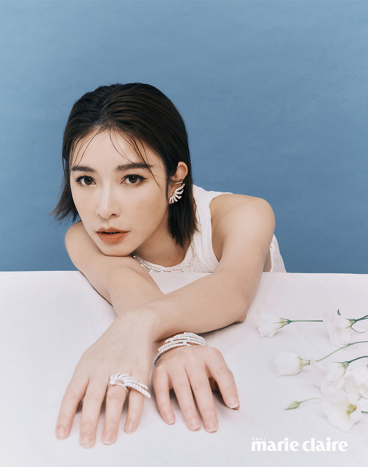 Vela 白K金法式鑲嵌鑽石耳環、Vela Crossover 白K金法式鑲嵌鑲滿鑽項鍊、Vela 白K金法式鑲嵌鑽石手鐲、Vela Solitaire 鉑金鑲鑽戒指、Vela 白K金法式鑲嵌鑽石戒指,all by Hearts On Fire;白色壓褶背心,Loewe。