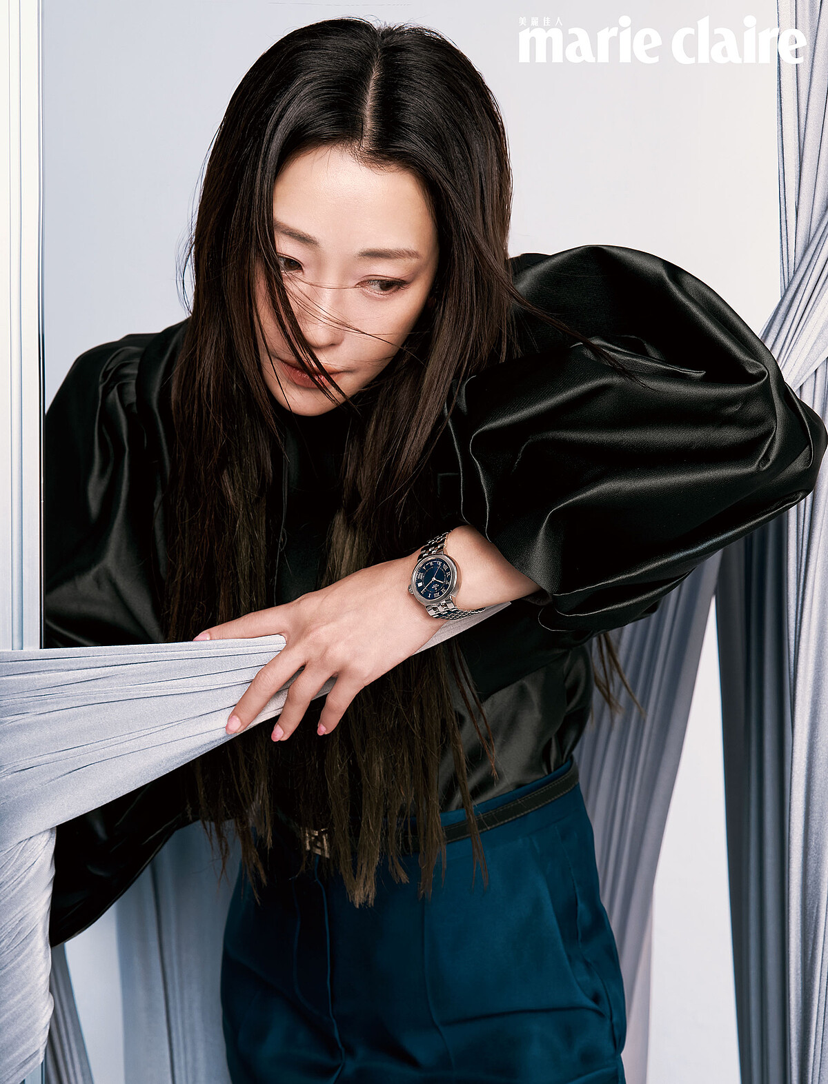 墨綠絲緞立體澎袖上衣、藍色絲緞高腰長褲、窄版金屬腰帶金屬球形耳飾，all by Fendi；CLAIR DE ROSE「帝舵藍款」，Tudor。