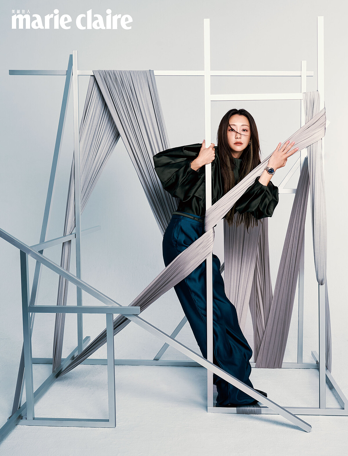 墨綠絲緞立體澎袖上衣、藍色絲緞高腰長褲、窄版金屬腰帶金屬球形耳飾、黑色亮面過膝長靴，all by Fendi；CLAIR DE ROSE「帝舵藍款」，Tudor。