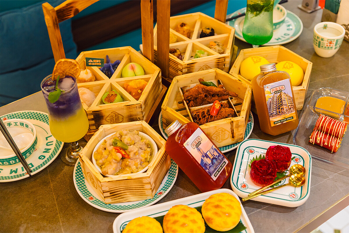  茶點左上到右下：一龍大滿足(酸菜魚、鹹蛋黃墨魚燒賣、蟹粉菠菜香蝦餃、松露野菌晶瑩餃、筍尖蝦餃皇、斑蘭麻蓉桃子)、港原味2.0燒賣拼盤(XO醬帶子燒賣、莞荽馬蹄燒賣、香辣雞軟骨燒賣、蘇薑馬友鹹魚燒賣、大澳蝦醬墨魚燒賣、梅菜扣肉燒賣)、黃椒醬排骨、鳳爪拚黑椒金錢肚、甘筍汁流沙包、拉絲波蘿包、宮廷桂花糕、脆脆富貴紅米腸粉。調酒飲品左起：日．夜、莫吉托