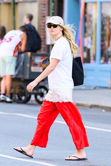 Jennifer Lawrence以白T、紅色寬褲搭配人字拖的街頭造型