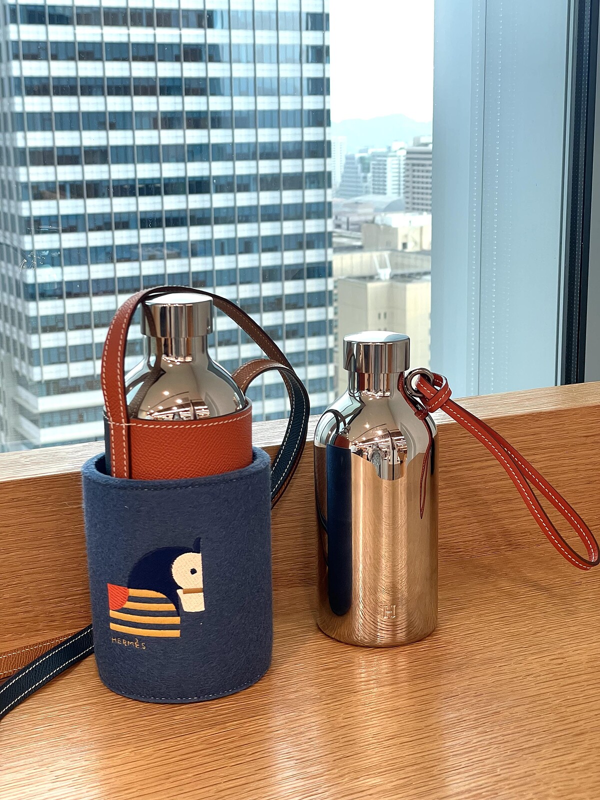 Herm&egrave;s Fl&acirc;neuse 隨身水瓶系列，流線鏡面外觀與撞色皮革手腕帶