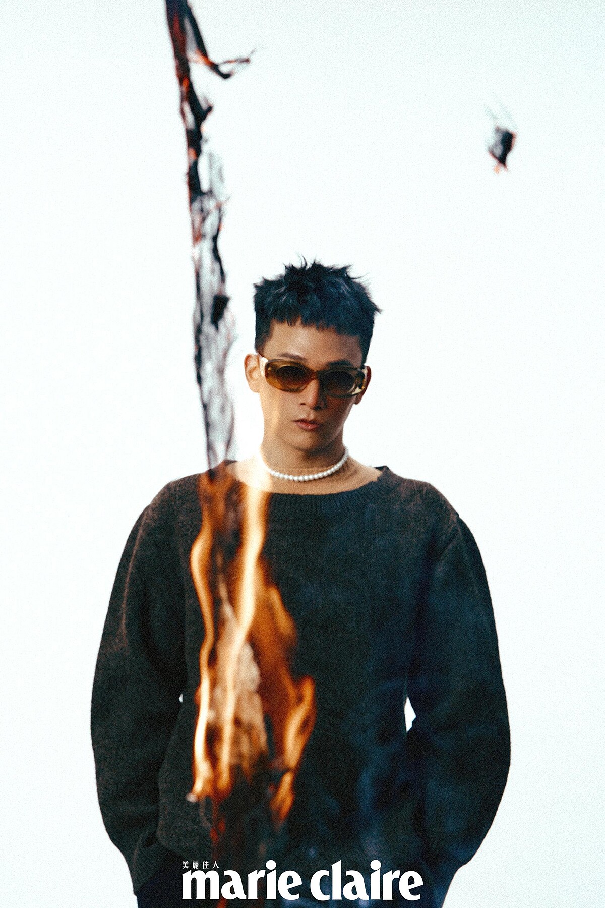 橘色短袖上衣、灰棕色毛衣，both by Prada；黑色西裝褲、琥珀色墨鏡 both by Loewe。琥珀色墨鏡，Loewe。