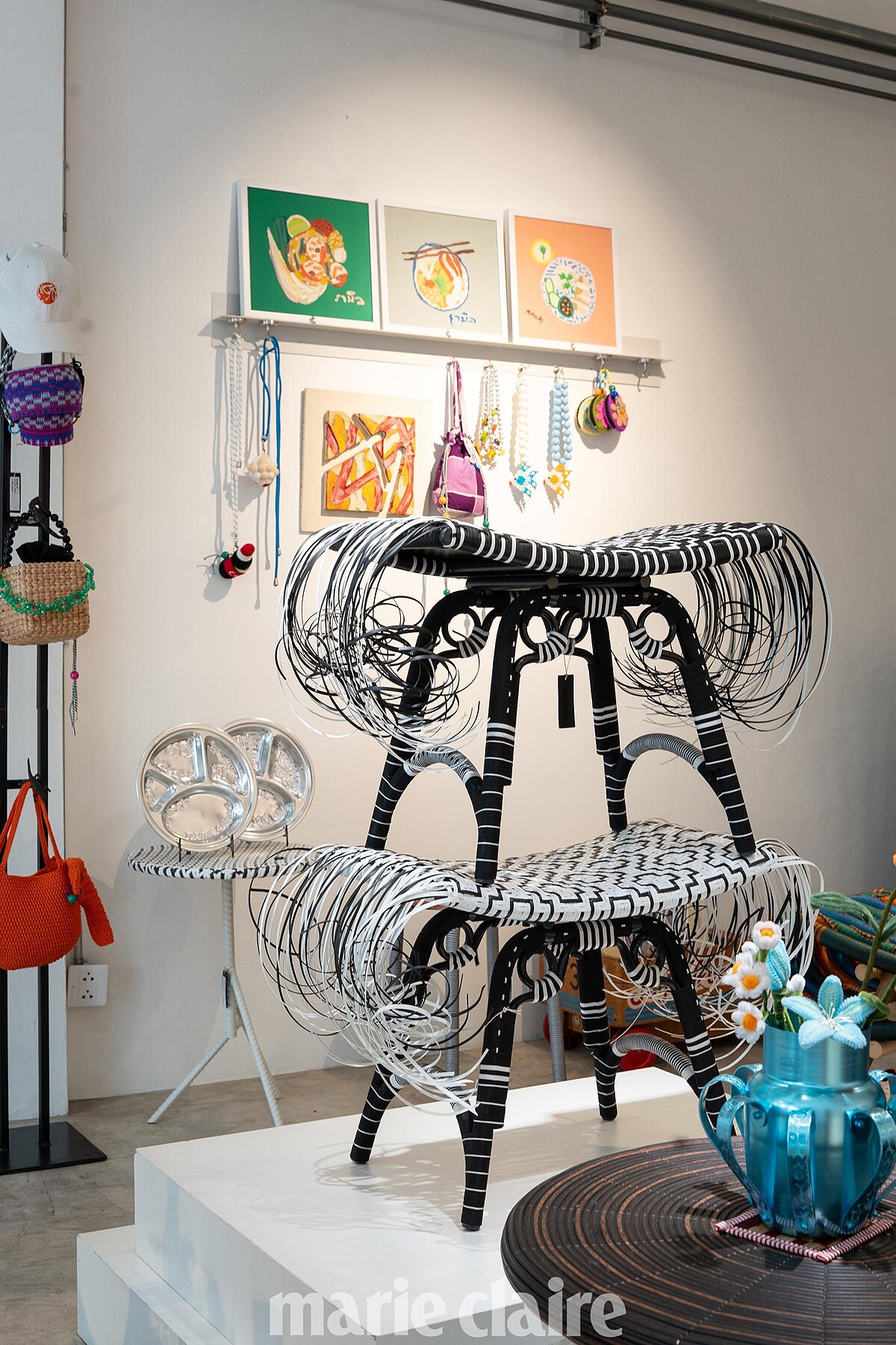 牆上的畫作出自 Na Kittikoon 基金會的學生之手，是 Jim Thompson、Kitt.Ta.Khon 和 ATT19 的合作計畫。不只是顏色和形式而已，還承載了年輕自閉症藝術家的聲音。收益的 70% 會直接回饋基金會和學生藝術家，用於支持藝術與音樂治療，讓創造力成為他們未來的可能。