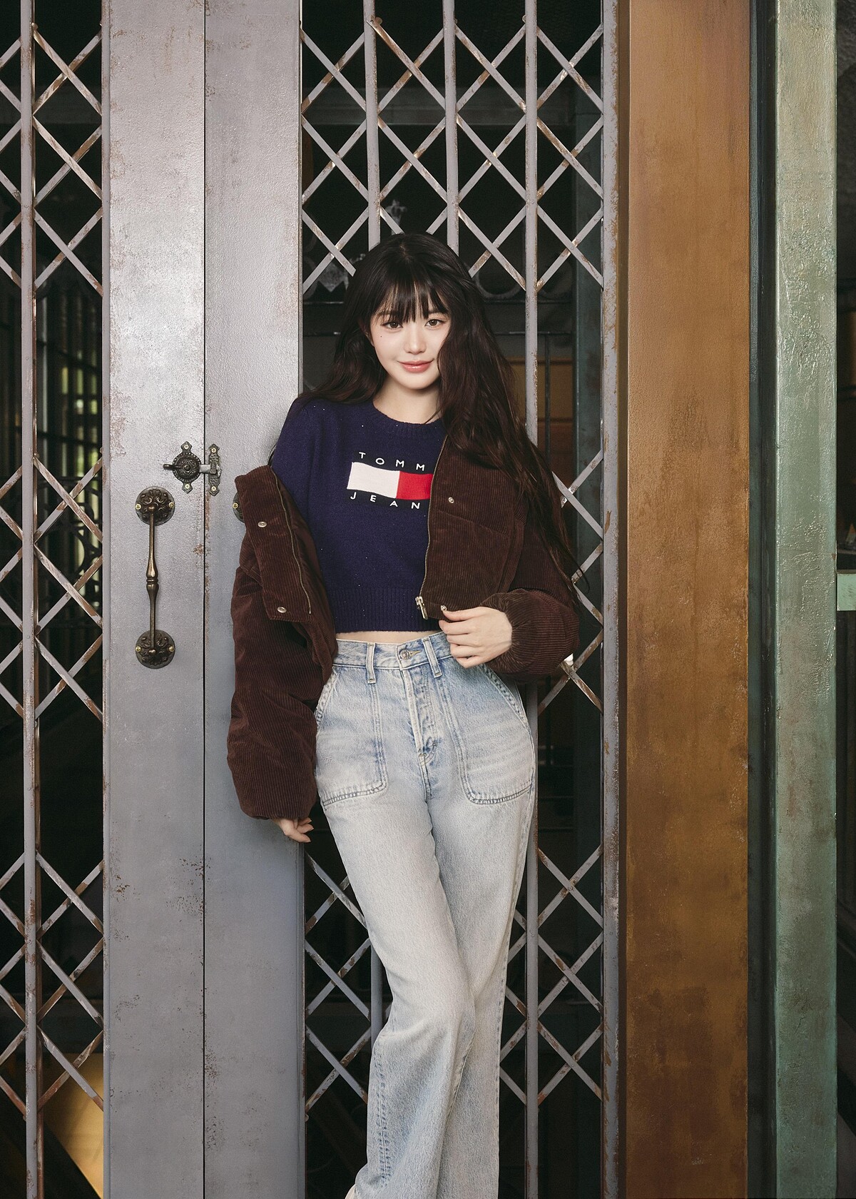 短版燈芯絨羽絨衣、旗幟徽章長袖毛衣、淺色水洗牛仔褲 by TOMMY JEANS。