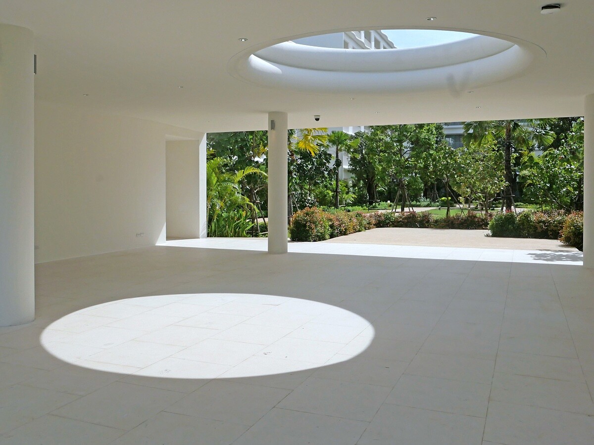 冷白色的建築表面在光線下宛如海浪倒影，營造出既現代又富有雕塑感的視覺效果。