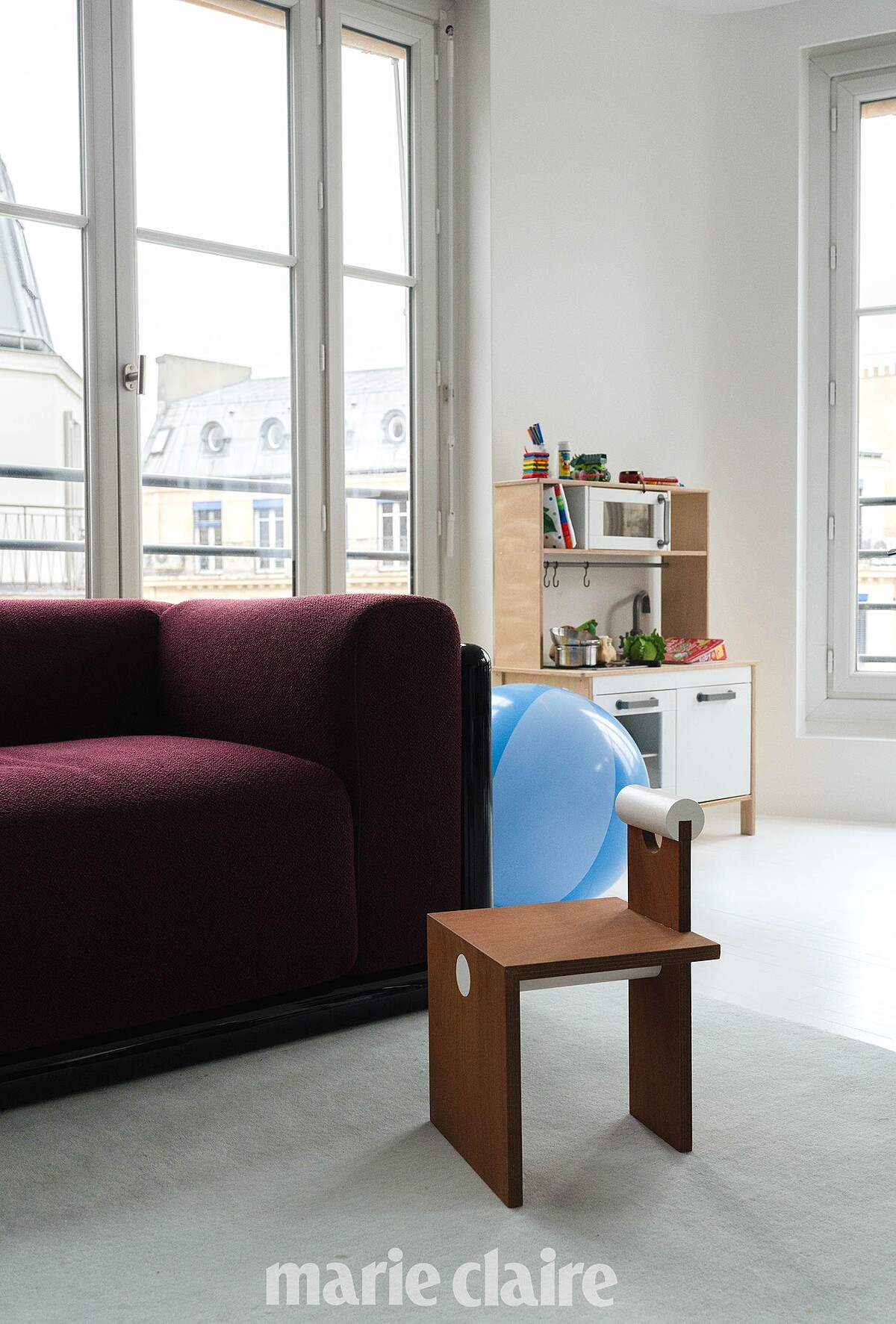 Adam 專屬的小座椅,是用走廊的木板材料製作的,後面則是他的玩具廚房。