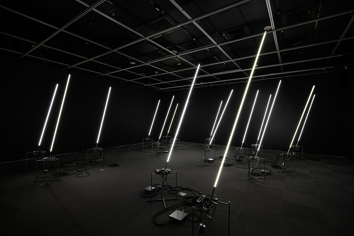 《風場II》將風的數據，轉化為機械與光影模擬自然律動，細長的發光體化為一片人工風林，在展場裡靜靜呼吸。｜展出現場｜當代館提供