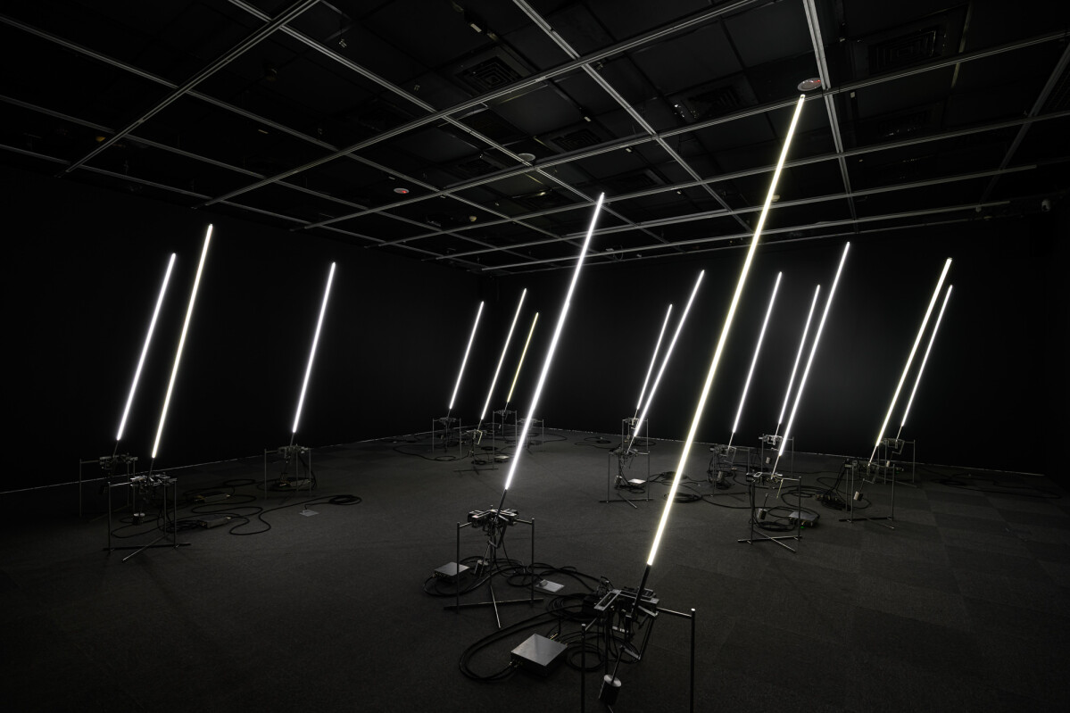 《風場II》將風的數據，轉化為機械與光影模擬自然律動，細長的發光體化為一片人工風林，在展場裡靜靜呼吸。｜展出現場｜當代館提供