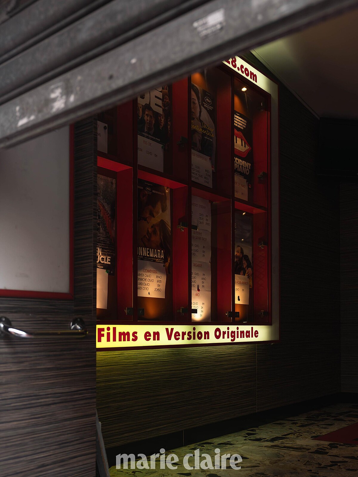 透露黃光的紅色燈箱，向大家展示上映中的電影海報。
