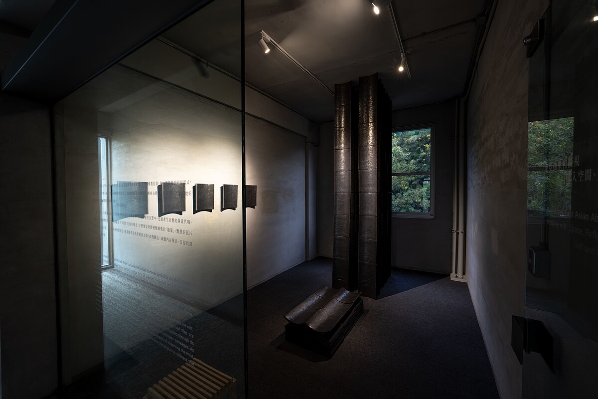 權純益以近十年每日反覆塗抹的石墨瓦片，在展間築造頂天觸地的巨型石碑；在光線照耀下，墨面如「心鏡」般由黯轉明，帶領觀者沿著墨韻光點走入藝術家的內在心畫。《The Bards of Time and Space 吟遊時空──霍剛 Ho Kan、權純益 Kwon Soonik》 &copy; 金馬賓館當代美術館 ALIEN Art Centre