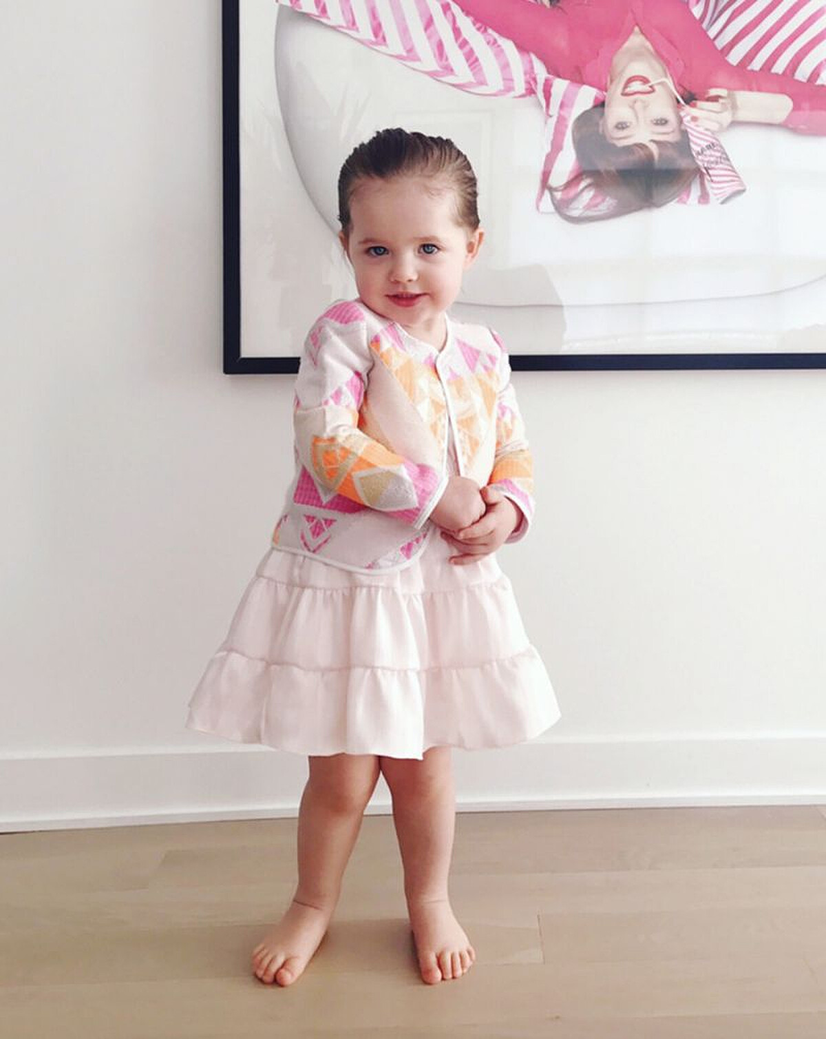 粉色的澎裙洋裝罩上剪裁立體的外套版型，再梳個乾淨的馬尾